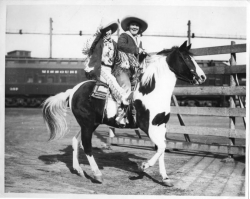 Legendary cowgirls, Ruth Roach and Tad Lucas, riding double in the Fort Worth Stockyards.   